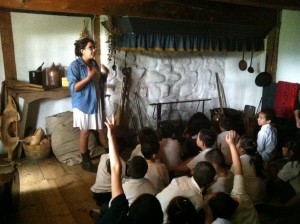 Elementary school students ask questions and share their observations of the open hearth in the Wyckoff farmhouse's Old Kitchen